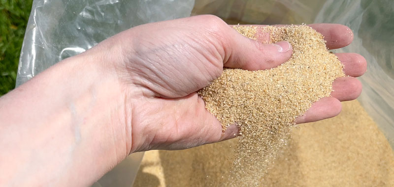 84-rasensand-2 Rasensand wird aus BigBag gegriffen