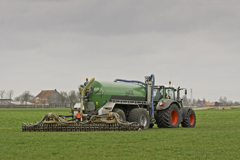 116-guelle-traktor Traktor verteilt Gülle auf einem Feld