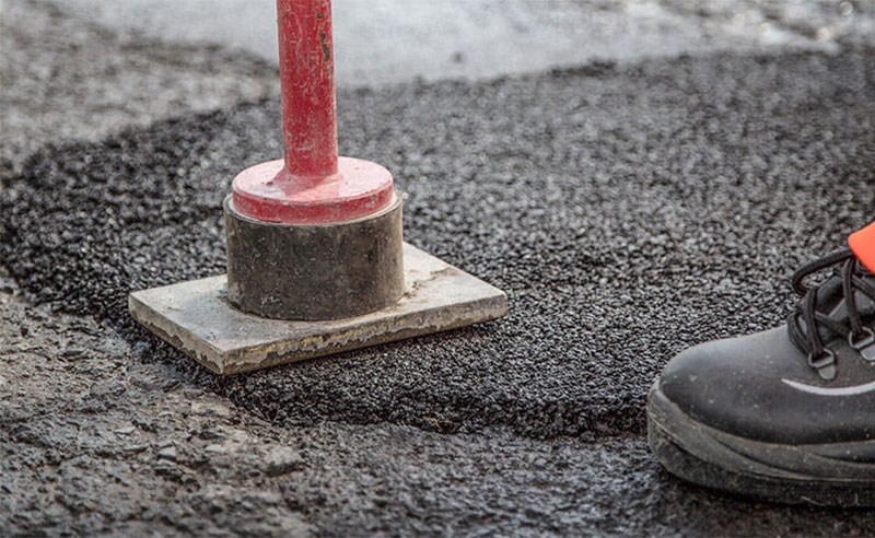 1-asphalt-verdichten Kaltasphalt wird mit Handstampfer verdichtet