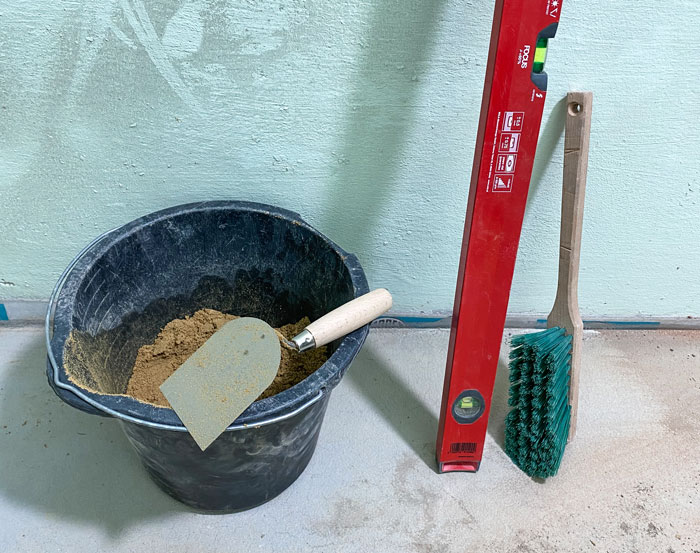 38-benoetigtes-material-1 Sandeimer, Wasserwage und Handbesen sind aufgereiht