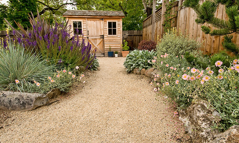 Mediterraner Garten mit Kalksplitt und Gartenhaus