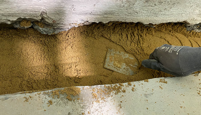 38-rohr-mit-sand-bedecken-8 Sand wird mit Mauerkelle verteilt