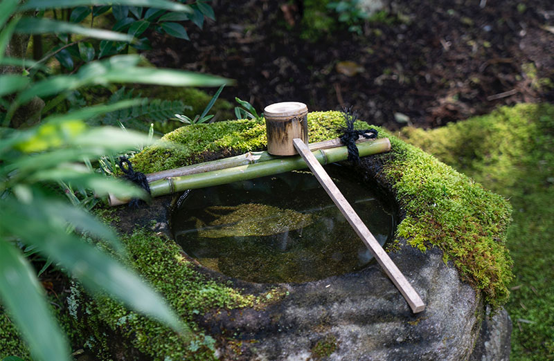 Bambuslöffel auf japanischem Brunnen